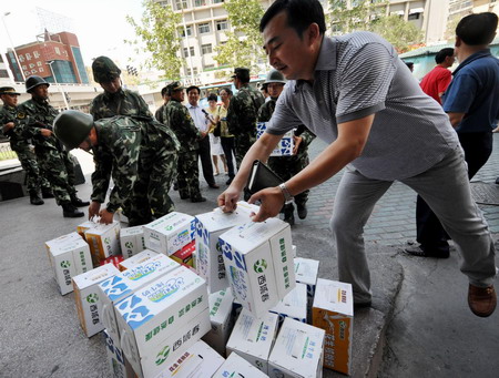 A man delivers beverage to the public security forces whose intrepid presence spared the riot-plagued city from further unrests, in Urumqi, northwest China's Xinjiang Uygur Autonomous Region, Friday July 10, 2009. [Xinhua]