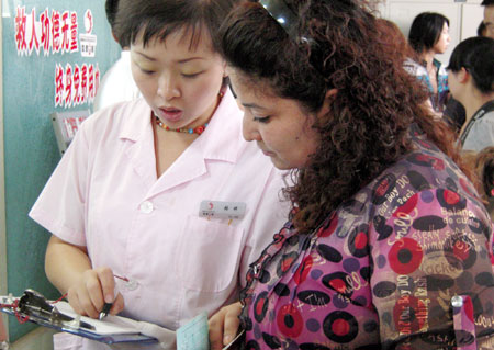 A nurse (L) guides people for blood donation for the wounded of the July 5 riot in Urumqi, capital of northwest China's Xinjiang Uygur Autonomous Region, July 10, 2009. [He Jun/Xinhua] 