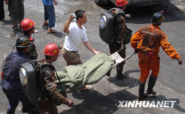 Rescuers carry out a miner who survived after being trapped in a flooded mine for 25 days in Qinglong County of southwest China's Guizhou Province on Sunday, July 12, 2009. [Photo: Xinhua] 