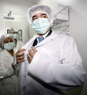 Thailand's Prime Minister Abhisit Vejjajiva wears a face mask before he enters Bio-safety Level 3 (BSL-3) lab, where a vaccine for the H1N1 (Influenza A) virus is being developed, at Silapakorn University on the outskirts of Bangkok July 12, 2009.[Xinhua/Reuters]