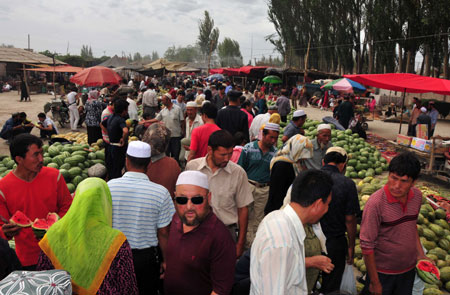 Photo taken on July 12, 2009 shows a bustling bazaar in Aksu, northwest China's Xinjiang Uygur Autonomous Region. Local residents of various ethnic groups went to bazaars, their traditional markets, for shopping on Sunday. [Xinhua]