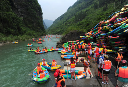 A slew of tourists enjoy the river-drifting tour on the air cushion vessels along the limpid brooks inside the Jiuwanxi Scenery Resort in Zigui County, central China's Hubei Province, July 11, 2009. [Xinhua]