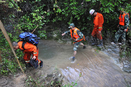 Rescuers search for survivors at the Tanzhangxia Canyon scenic spot, Wanzhou District of southwest China's Chongqing Municipality, July 12, 2009. Seven more bodies were retrieved Sunday from a flooded crude gorge in Chongqing Municipality, bringing the death toll from a rain-related hiking accident to 14, the rescue headquarters said.[Xinhua]