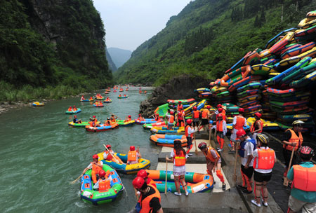 A slew of tourists enjoy the river-drifting tour on the air cushion vessels along the limpid brooks inside the Jiuwanxi Scenery Resort in Zigui County, central China's Hubei Province, July 11, 2009. [Zheng Jiayu/Xinhua]