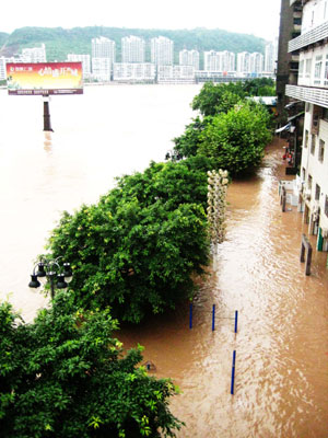 Photo taken on July 12, 2009 shows the flooded streets and houses beside Tongzhou Bridge in Dazhou City, southwest China's Sichuan Province. [Deng Liangkui/Xinhua]