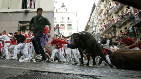 Miura bulls fall at the Estafeta corner on the sixth day of the running of the bulls at the San Fermin festival in Pamplona July 12, 2009.[Xinhua/Reuters]