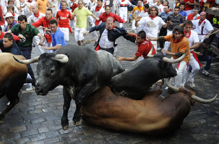 Miura bulls fall at the Estafeta corner on the sixth day of the running of the bulls at the San Fermin festival in Pamplona July 12, 2009.[Xinhua/Reuters]