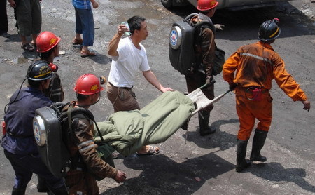 Rescuers carry one of the three survivors who have been trapped in a flooded mine for 25 days in Qinglong county, southwest China's Guizhou Province Sunday, July 12, 2009. [Xinhua]