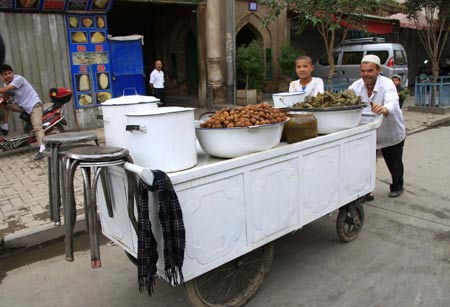 A vendor pulls a food cart in Kashgar city, northwest China's Xinjiang Uygur Autonomous Region, July 12, 2009. Businesses have recovered and prices have fallen to normal level in the city. [Xinhua]