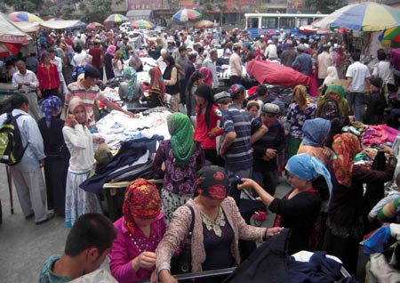 Photo taken on July 12, 2009 shows a bustling bazaar in Hotan, northwest China's Xinjiang Uygur Autonomous Region. Local residents of various ethnic groups went to bazaars, their traditional markets, for shopping on Sunday. [Xinhua]