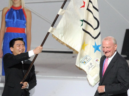 Acting Shenzhen mayor Wang Rong (L) waves the flag of the International University Sports Federation (FISU) during the closing ceremony of the 25th Universiade in Belgrade, capital of Serbia, July 12, 2009.(Xinhua/Jiao Weiping)