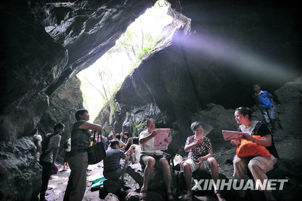 Citizens in Hangzhou relax in a natural cave beside the West Lake to avoid sunstroke on July 11, 2009. Many citizens in Hangzhou have taken to the caves around the West Lake to refresh from the summer heat. The caves, some natural and some artificial, used to be civil air defense shelters but are now open free to citizens. [Photo:Xinhuanet]