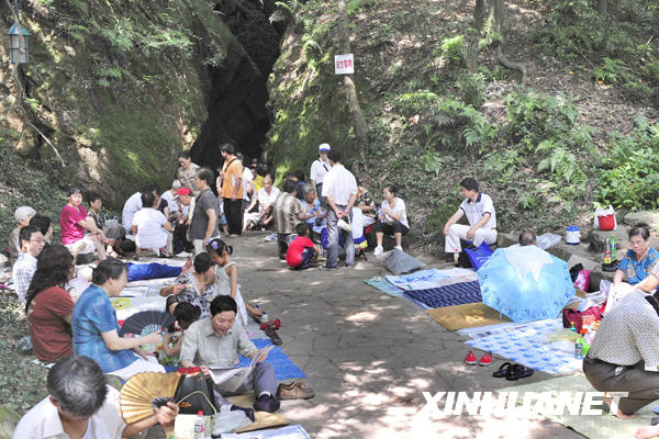Citizens in Hangzhou relax in a natural cave beside the West Lake to avoid sunstroke on July 11, 2009. Many citizens in Hangzhou have taken to the caves around the West Lake to refresh from the summer heat. The caves, some natural and some artificial, used to be civil air defense shelters but are now open free to citizens. [Photo:Xinhuanet] 