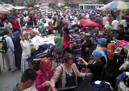 Photo taken on July 12, 2009 shows a bustling bazaar in Hotan, northwest China&apos;s Xinjiang Uygur Autonomous Region. Local residents of various ethnic groups went to bazaars, their traditional markets, for shopping on Sunday. (Xinhua/Zhao Ge)