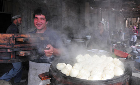 A vendor sells steamed stuffed bun at the largest bazaar in Aksu, northwest China&apos;s Xinjiang Uygur Autonomous Region, July 12, 2009. Local residents of various ethnic groups went to bazaars, their traditional markets, for shopping on Sunday. (Xinhua/Hou Jun)