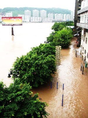 Photo taken on July 12, 2009 shows the flooded streets and houses beside Tongzhou Bridge in Dazhou City, southwest China's Sichuan Province.[Deng Liangkui/Xinhua]