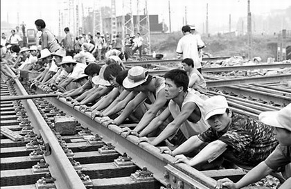 Workers lay rail track in Dazhou, Sichuan province. The government has invested heavily in West China on infrastructure projects in an attempt to close the economic gap between the West and China's wealthier provinces. [China Daily]