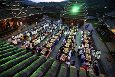 Tourists gather for dinner in the Dong Ethnic Autonomous County of Sanjiang in southwest China's Guangxi Zhuang Autonomous Region, July 12, 2009. The unique ethnic customs of Sanjiang County attracted so many tourists at home and abroad. [Xinhua]