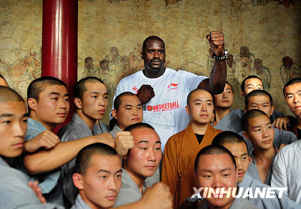 NBA Cleveland Cavaliers center Shaquille O'Neal (C) pose for a photo with monks during his promotional tour in Shaolin Temple, central China's Henan province, July 13, 2009. [Xinhua] 