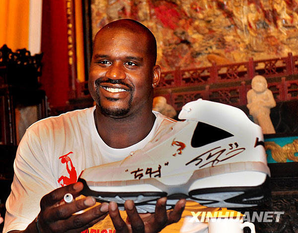 NBA Cleveland Cavaliers center Shaquille O'Neal (L) presents a basketball shoe with his signature during his promotional tour in Shaolin Temple, central China's Henan province, July 13, 2009. [Xinhua] 