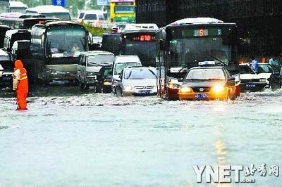 Vehicles are stranded in a flood caused by heavy rain in Beijing on Monday, July 13, 2009. [ynet.com]