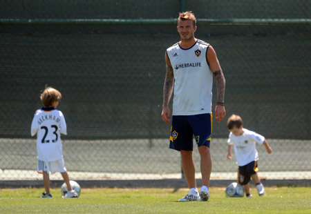 Los Angeles Galaxy's David Beckham, of England, takes part in soccer practice as his sons, Romeo, background left, and Cruz play with soccer balls in Carson, Calif., July 13, 2009. (Xinhua/AP Photo) 