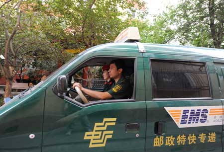 Two employees of the Urumqi Post Bureau drive to deliver a college admission letter in Urumqi, capital of northwest China's Xinjiang Uygur Autonomous Region, on July 14, 2009. (Xinhua/Xu Liang)