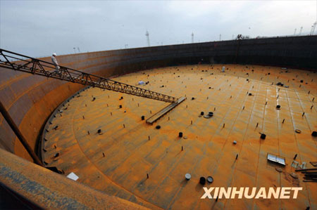  A crude oil storage tank with a capacity of 100,000 cubic meters is under construction in Shanshan, Northwestern China's Xinjiang Uygur Autonomous Region, on Monday, July 13, 2009. As China's biggest crude oil reserve base, Shanshan oil reserve base is designed to have a total capacity of 8,000,000 cubic meters. So far, 10 crude oil tanks of similar capacity have been put into use and others are still under construction. [Photo: Xinhuanet] 