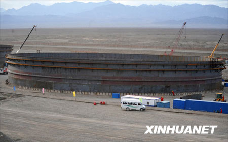 A crude oil storage tank with a capacity of 100,000 cubic meters is under construction in Shanshan, Northwestern China's Xinjiang Uygur Autonomous Region, on Monday, July 13, 2009. As China's biggest crude oil reserve base, Shanshan oil reserve base is designed to have a total capacity of 8,000,000 cubic meters. So far, 10 crude oil tanks of similar capacity have been put into use and others are still under construction. [Photo: Xinhuanet] 