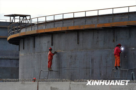 Technical staff do the polishing and joint work on the 100,000-cubic-meter crude oil storage tank in the east part of Xinjiang Uygur Autonomous Region on Monday, July 13, 2009. Construction of China's biggest crude oil reserve base is going smoothly. [Photo: Xinhuanet] 