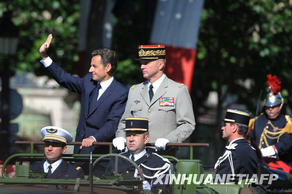 French President Nicolas Sarkozy waves to people during the National Day parade in Paris, France, July 14, 2009. France celebrated its National Day here on Tuesday. [Xinhua/AFP] 