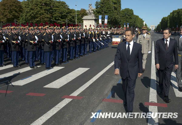 French President Nicolas Sarkozy waves to people during the National Day parade in Paris, France, July 14, 2009. France celebrated its National Day here on Tuesday. [Xinhua/Reuters] 