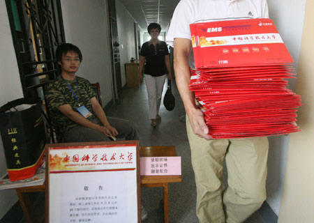 A total of 60 admission letters are picked up by a postman from University of Science and Technology of China in Hefei, capital of east China's Anhui Province, July 13, 2009. The first admission letters of universities and colleges in Anhui Province this year were released on Monday through post system. [Wang Zhiqiang/Xinhua]