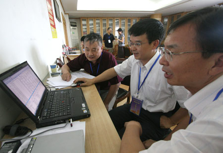 Teachers update information of the on-line enrolling system at University of Science and Technology of China in Hefei, capital of east China's Anhui Province, July 13, 2009. The first admission letters of universities and colleges in Anhui Province this year were released on Monday through post system. [Wang Zhiqiang/Xinhua]