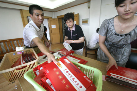 A postman picks up sealed admission letters from University of Science and Technology of China in Hefei, capital of east China's Anhui Province, July 13, 2009. The first admission letters of universities and colleges in Anhui Province this year were released on Monday through post system. [Wang Zhiqiang/Xinhua]