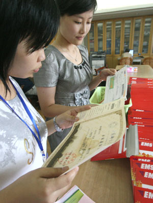 Enrolling officers check information on the admission letters at University of Science and Technology of China in Hefei, capital of east China's Anhui Province, July 13, 2009. The first admission letters of universities and colleges in Anhui Province this year were released on Monday through post system. [Wang Zhiqiang/Xinhua]