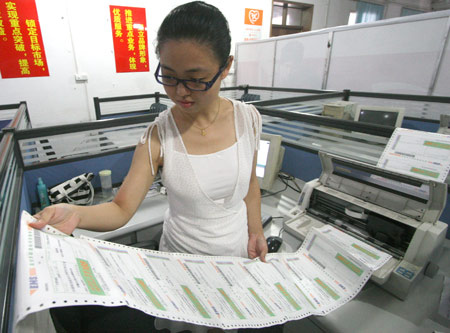 An enrolling officer checks mail addresses of the admission letters at University of Science and Technology of China in Hefei, capital of east China's Anhui Province, July 13, 2009. The first admission letters of universities and colleges in Anhui Province this year were released on Monday through post system. [Wang Zhiqiang/Xinhua]