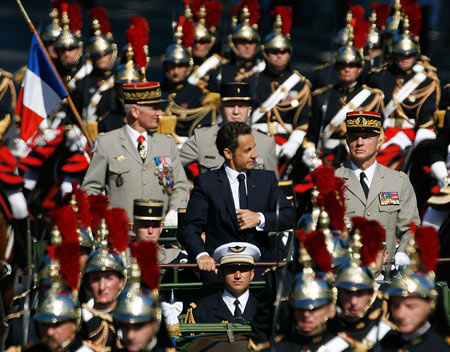 France's President Nicolas Sarkozy rides in a military command car, accompanied by the Republican Guard, as he rides down the Champs Elysees avenue on Bastille Day in Paris, July 14, 2009.[Xinhua/Reuters]