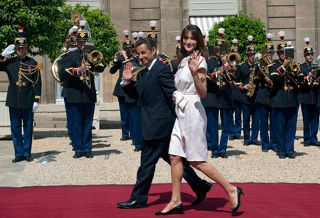 France's President Nicolas Sarkozy and his wife Carla Bruni-Sarkozy arrive at the Elysee Palace following the Bastille day parade in Paris, July 14, 2009.[Xinhua/Reuters]