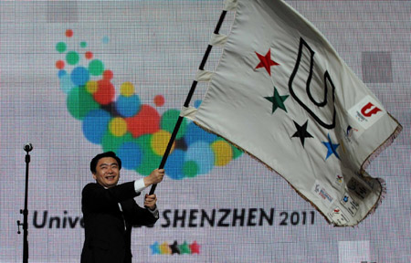 Acting Shenzhen Mayor Wang Rong waves the flag of the International University Sports Federation (FISU) during the closing ceremony of the 25th Universiade in Belgrade, capital of Serbia, July 12, 2009. (Xinhua/Wu Wei)