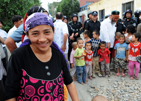 A Uygur woman smiles to the camera on Pingding Hill in Urumqi, capital of northwest China's Xinjiang Uygur Autonomous Region, July 14, 2009