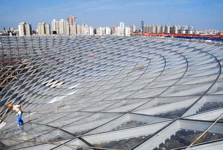 Workers install glass wall at the Sun Valley in the Shanghai Expo Site, Shanghai, east China, July 14, 2009. The glass wall installation of the Expo Axis Sun Valley was about to complete soon. The project of Expo Axis is scheduled to be completed by the end of this year. [Photo: Xinhua] 