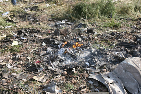 Debris is seen at the crash site of the Caspian Airlines plane, which fell into farmland near the city of Qazvin, northwest of Tehran on July 15, 2009. The Iranian airliner en route to neighbouring Armenia crashed on Wednesday, killing all 168 people on board in the worst air disaster in Iran in recent years. [Liang Youchang/Xinhua]