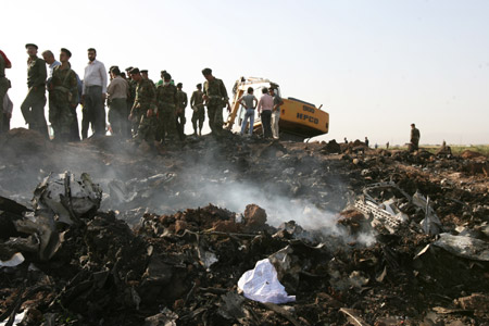 Iranian soldiers gather at the crash site of the Caspian Airlines plane, which fell into farmland near the city of Qazvin, northwest of Tehran on July 15, 2009. [Liang Youchang/Xinhua]