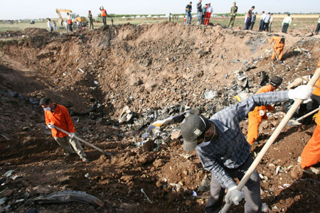 Rescuers work in a huge concave left by the crashed Caspian Airlines plane, which fell into farmland near the city of Qazvin, northwest of Tehran on July 15, 2009. The Iranian airliner en route to neighbouring Armenia crashed on Wednesday, killing all 168 people on board in the worst air disaster in Iran in recent years. [Liang Youchang/Xinhua]