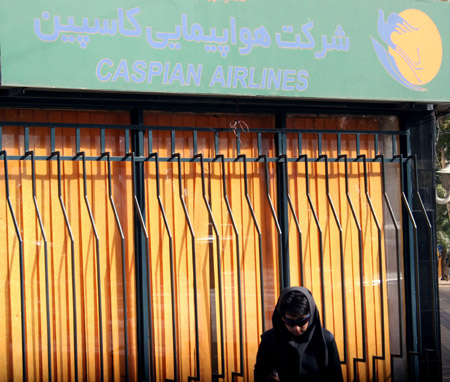 A woman walks past a ticket office of Caspian Airlines in Tehran, capital of Iran, on July 15, 2009. An Iranian airliner en route to neighbouring Armenia crashed on Wednesday, killing all 168 people on board in the worst air disaster in Iran in recent years. [Ahmad Halabisaz/Xinhua]