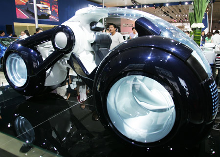 A visitor looks at a Peugeot concept car during the opening of the 6th China Changchun International Auto Expo, in Changchun, capital of northeast China's Jilin Province, July 15, 2009. [Yao Qilin/Xinhua]