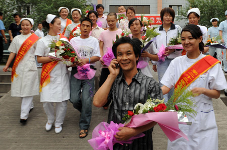  Yan Cailu, who was wounded in the July 5 riot, calls his relatives as he leaves the hospital in Urumqi, capital of northwest China's Xinjiang Uygur Autonomous Region, July 15, 2009. Twelve of the twenty-two people who received treatment in the 23rd Hospital of the People's Liberation Army (PLA) after being wounded in the July 5 riot in Urumqi left the hospital on Wednesday as they recovered from the wounds. [Xinhua]