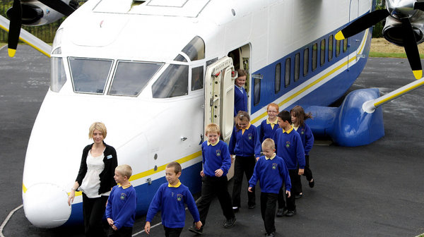 Year 3 and year 4 pupils and teacher Anne Grattage (left) from Kingsland Primary School in Stoke on Trent, with the plane they use as a classroom. [CFP]