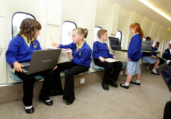 Year 3 and year 4 pupils from Kingsland Primary School in Stoke on Trent, with the plane they use as a classroom. [CFP]